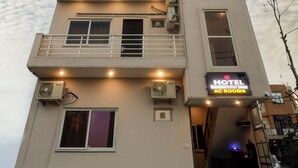 A hotel with multiple floors, balconies, and air conditioning units. - Hotel Saraswati Stay Dham (Vrindavan)