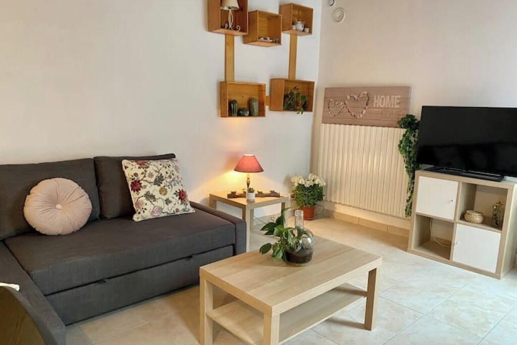 Een woonkamer met een bank, een salontafel, een televisie en een kast.