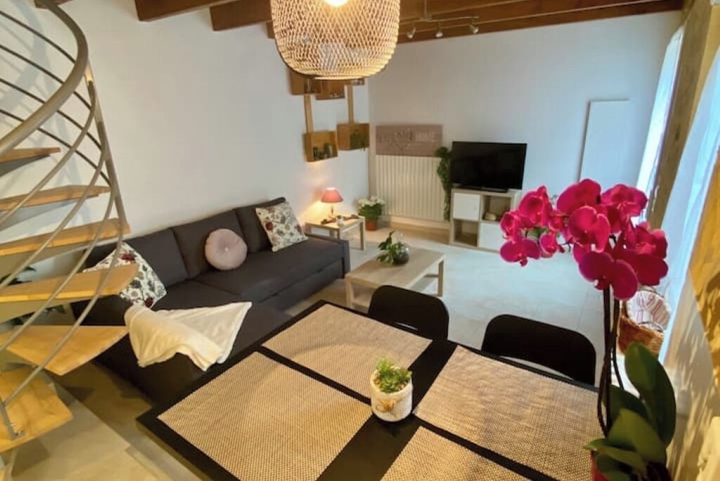 Un salon moderne avec un canapé, une table à manger et un téléviseur.