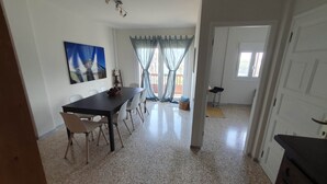 A dining area with a table and chairs, a painting on the wall, and a view through a door. - Apartamento vista Mar Caleta de Interián - Casa Oceano (La Caleta de Interián)