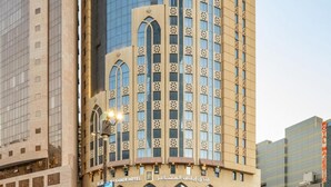 A hotel with a curved facade, large windows, and a prominent entrance with arches. - Prestige Al Mashaer Hotel (Makkah)