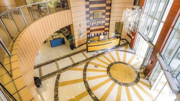 A hotel lobby with a reception desk, seating area, and a grand staircase. - Prestige Al Mashaer Hotel (Makkah)