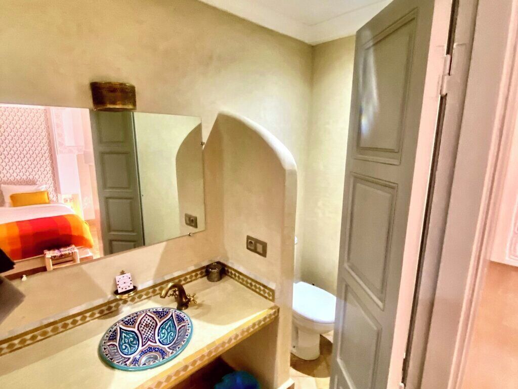 A bathroom with a sink, mirror, and toilet.