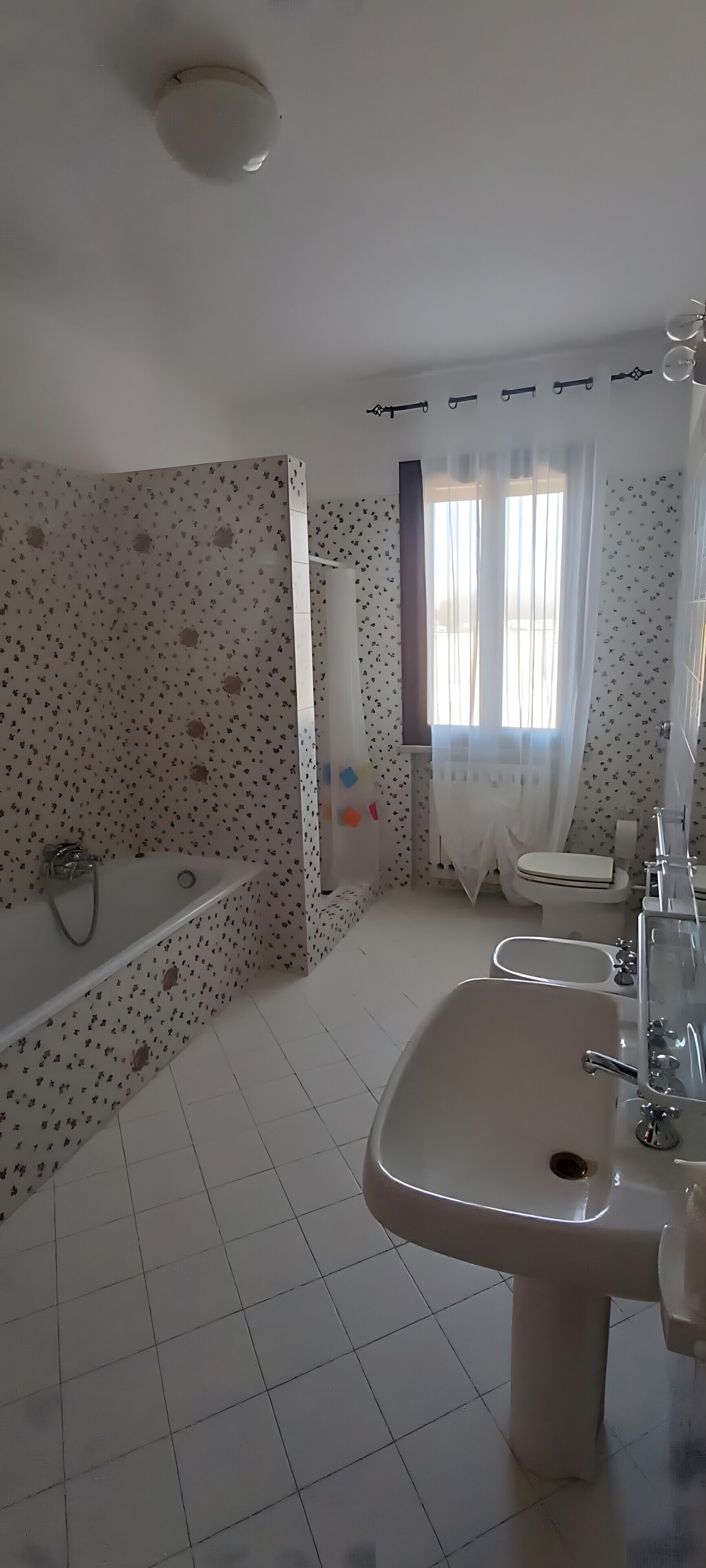 A bathroom with a bathtub, sink, toilet, and a shower area.