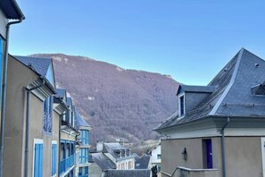 Eine Straße mit Gebäuden und einem Berg im Hintergrund.