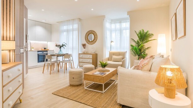 A modern living room with a sofa, coffee table, and a dining area with chairs and a table. - GuestReady - Modern and Cozy studio in Madrid (Madrid)