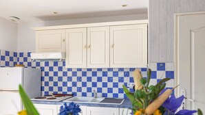 A kitchen with white cabinets, a blue and white checkered backsplash, and a white stove. - Guest Room “Dakar” with Shared Pool, Wi-Fi, and Air Conditioning (Saint-Pierre-d'Oléron)