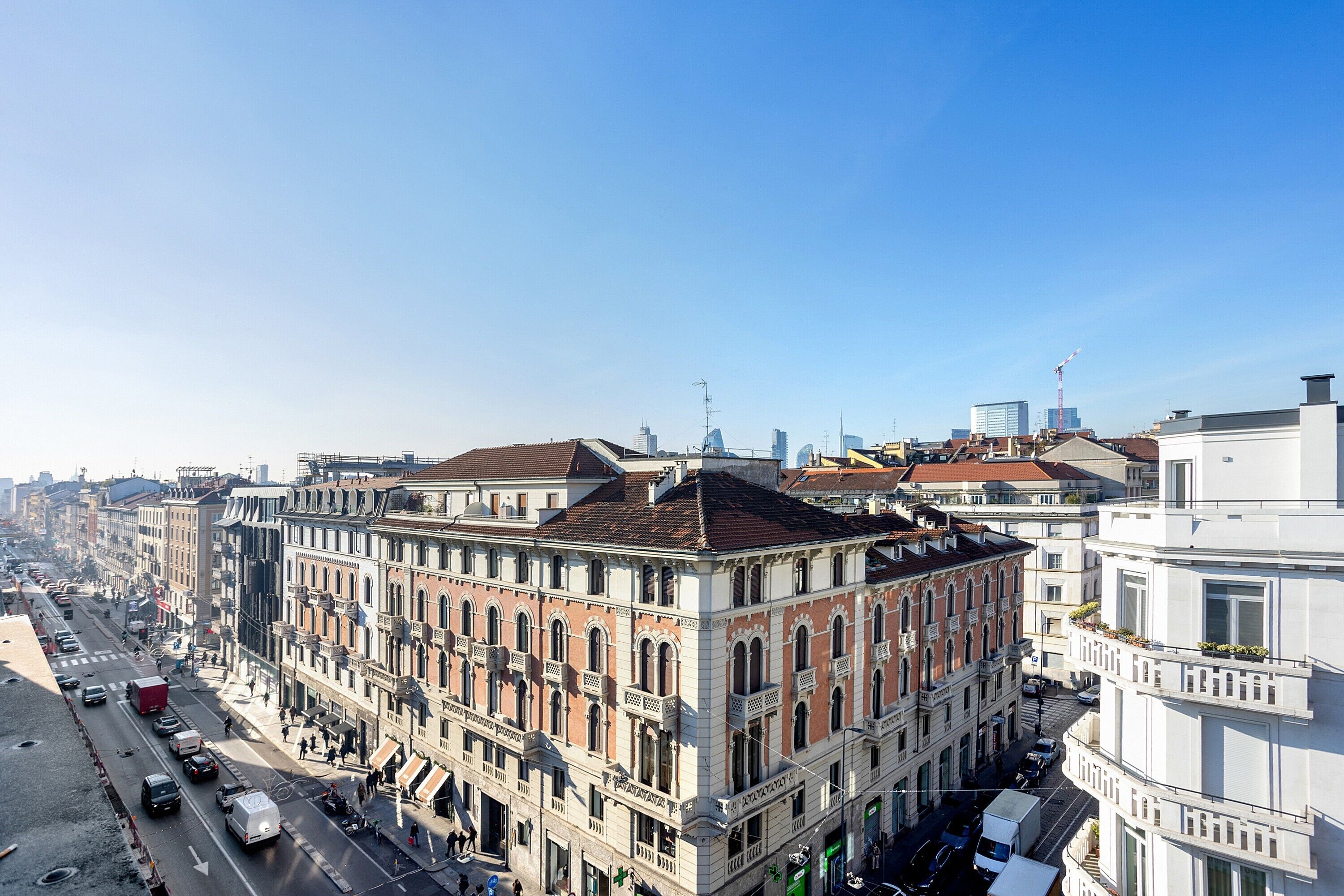Ein mehrgeschossiges Gebäude im klassischen Stil, mit einem zentralen Innenhof und einer zur Straße hin gerichteten Fassade mit zahlreichen Fenstern und Balkonen.