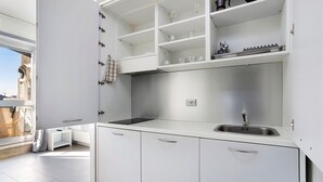 A modern kitchen with white cabinetry, a stainless steel sink, and a window overlooking a cityscape. - Apartment 'Smart Central 5' with Balcony, Wi-Fi and Air Conditioning (Milan)