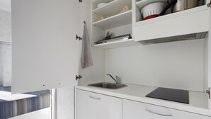 Une cuisine moderne dotée d’un évier encastré, de meubles blancs et d’un plan de travail.