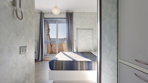 Une chambre à coucher avec un lit, une fenêtre avec des rideaux, un luminaire au plafond et une porte.
