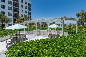 Une terrasse sur le toit avec des sièges d’extérieur, un barbecue et une pergola.