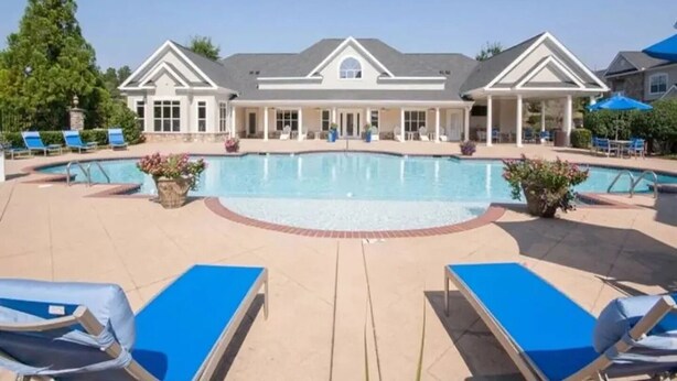 A large swimming pool with lounge chairs and a covered patio area. - Landing | Stunning 1BD, Gym, Tennis Court (Stockbridge)