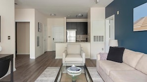 A modern apartment with a living room, a kitchen, and a dining area.