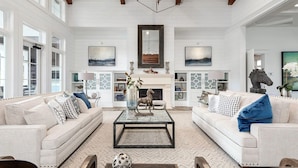 A spacious living room with two sofas, a coffee table, and a fireplace. - Landing | Incredible 2BD, Pool, Gym (Summerville)