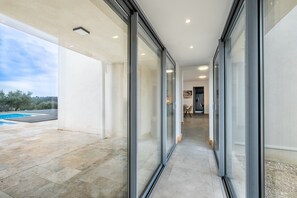 Een modern gebouw met een glazen doorgang naar een zwembad.
