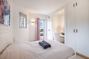 Ein Schlafzimmer mit Bett, Schreibtisch und Kleiderschrank.