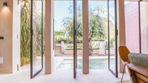 Un'ampia stanza con grandi vetrate scorrevoli che danno su una zona esterna con piscina e area relax.