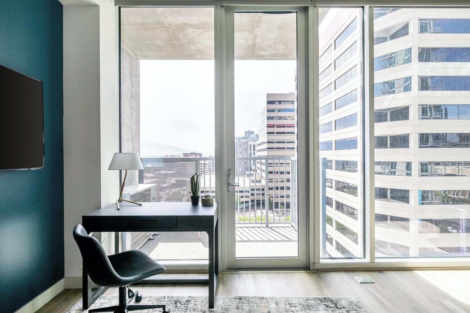 Un ufficio moderno con scrivania, sedia e una grande finestra che si affaccia su una vista panoramica della città.