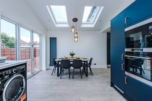 A modern kitchen with skylights, a dining area, and a built-in oven. - 3 Bed Hale Home | Free Parking (Hale)