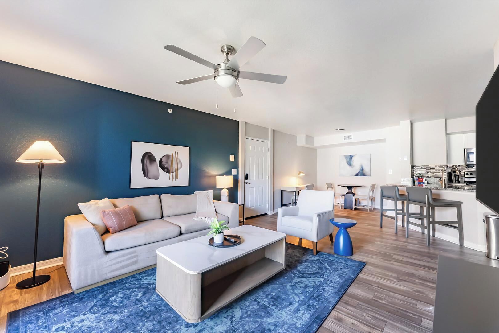 Un salon moderne avec un canapé, une table basse et un ventilateur de plafond.