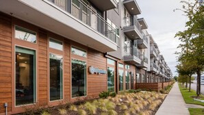 A modern multi-story building with a restaurant named "Magnolia" on the ground floor. - Landing | Stunning Studio, Gym, Pool (Dallas)