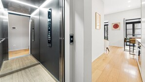 Un ascensore moderno con un display digitale, pavimento in legno e arredamento dal design minimalista.