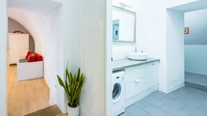 Ein modernes Badezimmer mit Waschbecken, Spiegel und Waschmaschine.