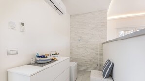 A modern bathroom with a white vanity, a towel rack, and a shower area. - RELAIS ROMA BEACH (Fiumicino)