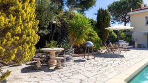 A stone patio with a pool, outdoor furniture, and a variety of trees and plants. - Holiday Home 'Petite Maison' with Shared Pool, Communal Terrace and Wi-Fi (Carry-le-Rouet)