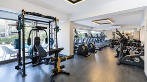 Un gimnasio moderno con diversos equipos de ejercicio, incluyendo una estructura para sentadillas, cintas de correr y máquinas de pesas.