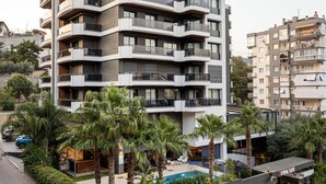 Un edificio residencial de varios pisos con balcones, piscina y un restaurante llamado UTOPIA SUITE.
