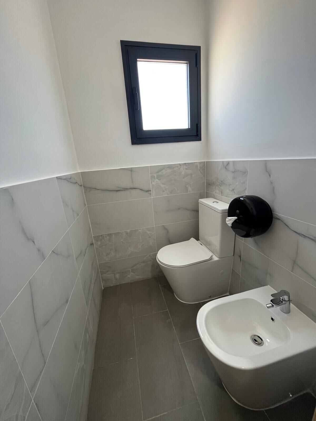 A bathroom with a toilet, bidet, and sink.