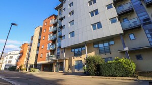 A multi-story residential building with balconies, a gated entrance, and a clear sky. - Seabreeze Suites (Southampton)
