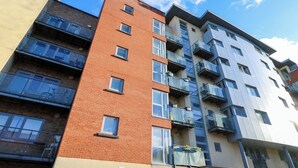 A multi-story residential building with balconies, a mix of brick and modern facade, and a clear sky. - Seabreeze Suites (Southampton)