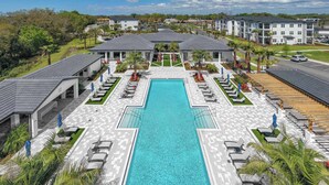 Ein großer Pool mit Liegestühlen und einer überdachten Terrasse.
