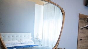 Ein Schlafzimmer mit einem Bett, einem Nachttisch, einem Spiegel und einem Holzschrank.
