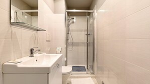 A modern bathroom with a glass-enclosed shower, a white sink, and a toilet. - Orchid Room – Double with Wi-Fi, A/C, and Accessible Bathroom (Prato)