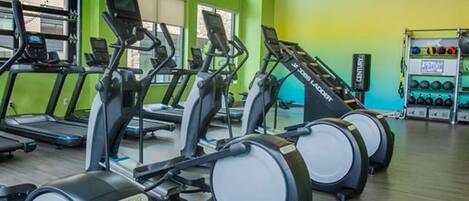 A gym with treadmills, exercise balls, and a weight rack.