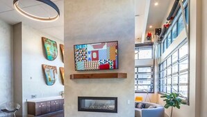 Um lobby moderno com lareira, área de estar e obras de arte nas paredes.