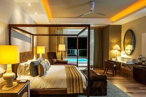 A four-poster bed with a view of a pool, a desk with a chair, and a large mirror on the wall. - Luxurious 3BR/4BA Residence Loft - Grand Luxxe Nuevo Vallarta (Nuevo Vallarta)