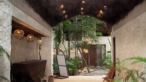 A spacious indoor area with a thatched ceiling, stone walls, and hanging spherical lights. There is a wooden bench and a display board in the center. - Ph 10mins from tulum beach, with private pool and spa, ideal for families. (Tulum)