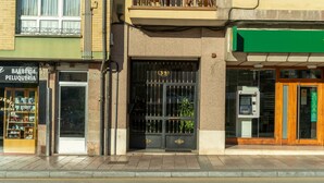 Un edificio con escaparate que muestra una barbería y un toldo verde.