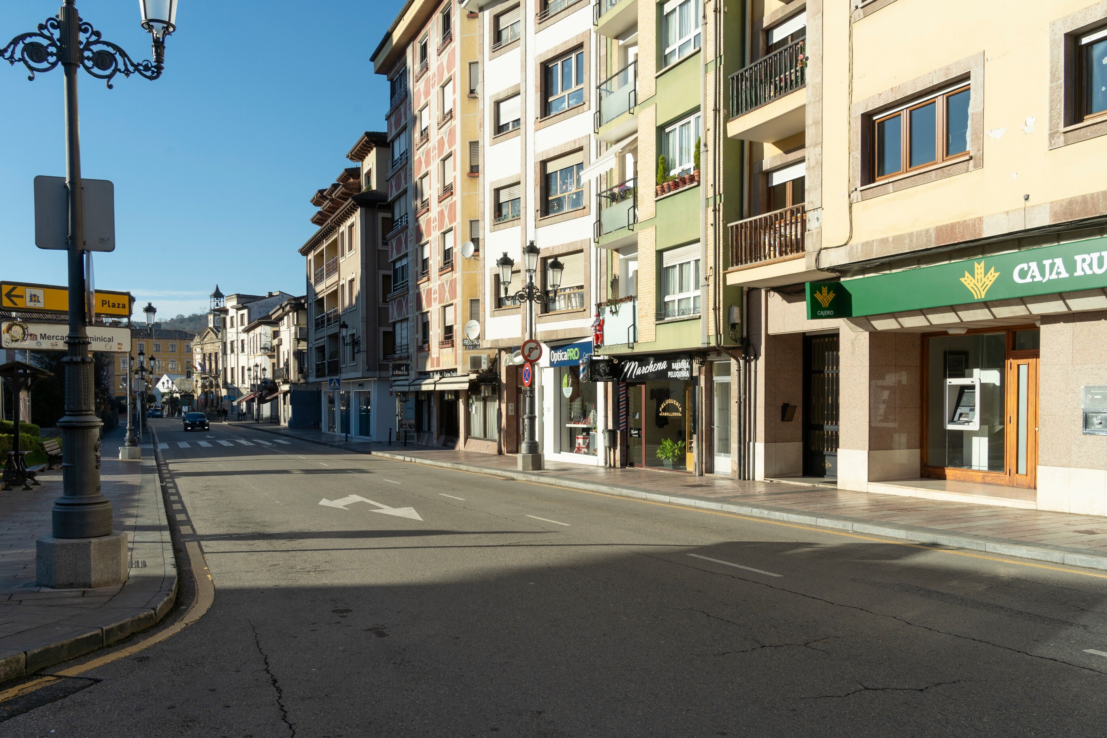 Une rue bordée d’immeubles, une enseigne indiquant « Plaza », et un établissement appelé « Caja Rúa ».