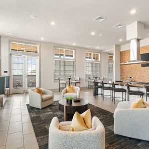 A spacious living area with a sofa set, a coffee table, and a dining area with chairs and a table.