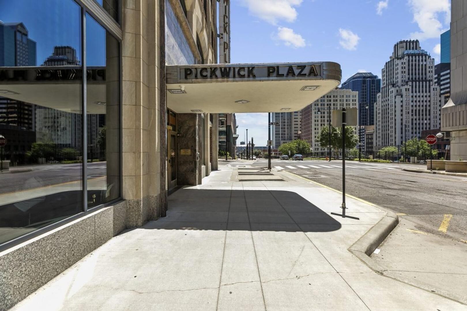 Entrada d'un edifici amb un rètol que diu "Pickwick Plaza" i una vorera que condueix a un carrer.