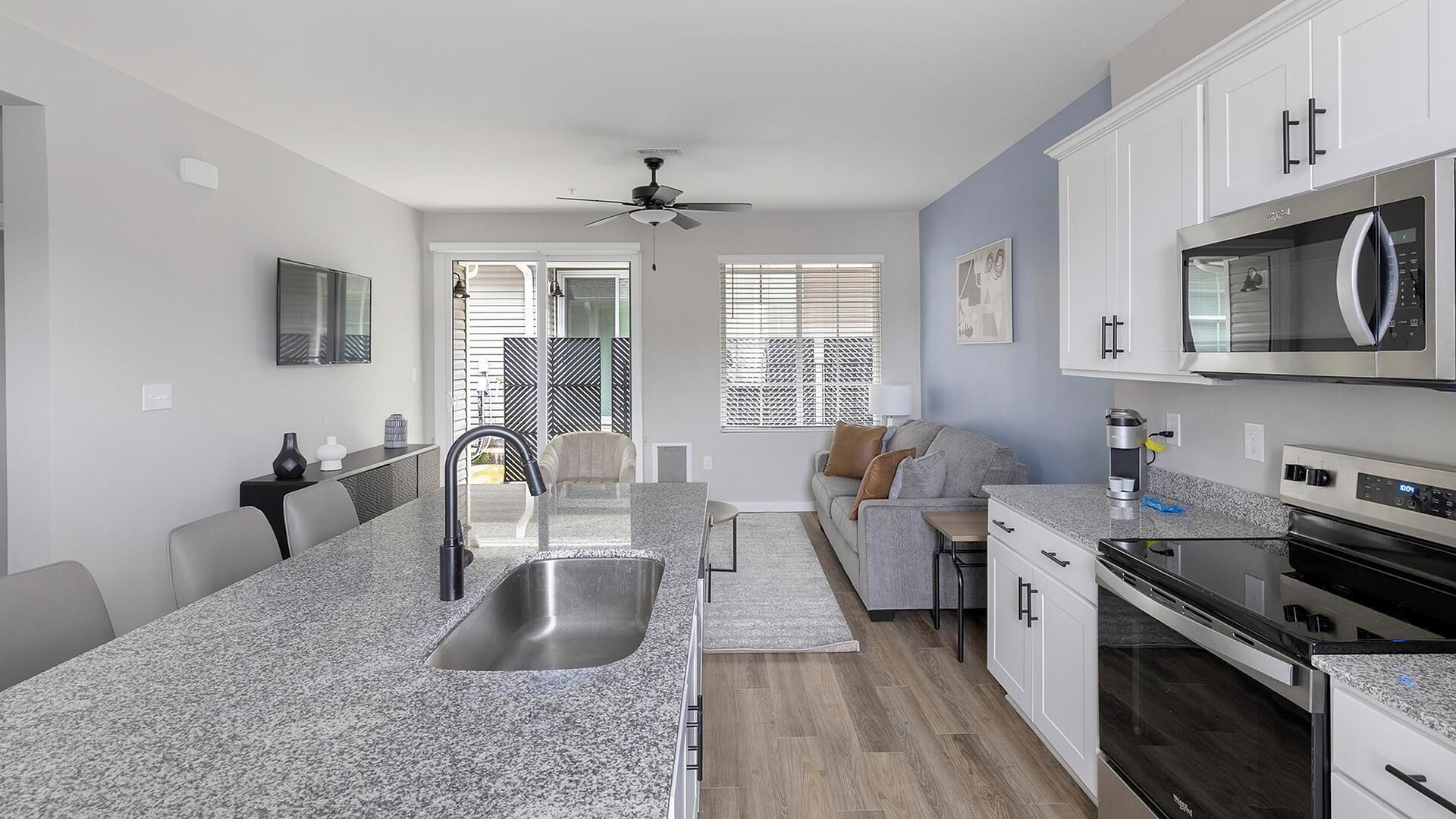 A modern kitchen with granite countertops, stainless steel appliances, and a central island with a sink.