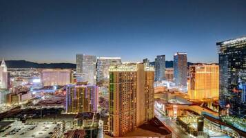 A cityscape at night with illuminated buildings, including a prominent hotel with a sign.