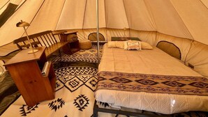 A tent with a bed, a desk, and a chair.