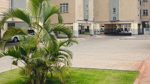 A multi-story building with a parking area in front. - Regal Suites (Athi River)